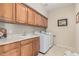 Well-equipped laundry room with sink, cabinets, and modern washer and dryer for added convenience at 26011 W Tonopah Dr, Buckeye, AZ 85396