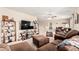 Living room with ceiling fan, large sofa, tv and a view of the dining area at 26011 W Tonopah Dr, Buckeye, AZ 85396