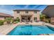 Backyard features a sparkling pool, covered patio, and meticulously maintained landscaping for outdoor enjoyment at 26011 W Tonopah Dr, Buckeye, AZ 85396