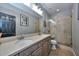 Bathroom featuring a double sink vanity and glass-enclosed shower at 27173 N 86Th Ave, Peoria, AZ 85383