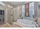 Bathroom featuring a soaking tub, glass enclosed shower, and double sink vanity at 27173 N 86Th Ave, Peoria, AZ 85383