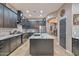 Modern kitchen with dark cabinets, stainless steel appliances, and a large center island with granite countertops at 27173 N 86Th Ave, Peoria, AZ 85383