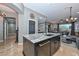 Kitchen island with a granite countertop and a sink overlooking the living room at 27173 N 86Th Ave, Peoria, AZ 85383