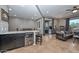 Open concept living room with a granite countertop bar, wine cooler, leather sofa, and a sliding glass door at 27173 N 86Th Ave, Peoria, AZ 85383