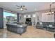 Spacious living room with large windows, two sofas, and a ceiling fan at 27173 N 86Th Ave, Peoria, AZ 85383