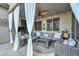 Inviting covered patio area with stylish wicker furniture, draped curtains, ceiling fan, and decorative accents at 27173 N 86Th Ave, Peoria, AZ 85383