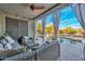 Relaxing covered patio with cozy seating, a ceiling fan, and views of the sparkling pool and landscaped backyard at 27173 N 86Th Ave, Peoria, AZ 85383