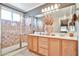 Bathroom featuring double sinks, light wood cabinets, decorative mirror, and a tiled walk-in shower at 2862 N 156Th Dr, Goodyear, AZ 85395