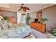 Bedroom with a floral bedspread, wooden dressers, and a ceiling fan at 2862 N 156Th Dr, Goodyear, AZ 85395