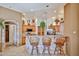 Inviting kitchen with a stone-clad breakfast bar, tile flooring, wooden cabinets and stainless steel appliances at 2862 N 156Th Dr, Goodyear, AZ 85395