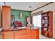 Traditional home office with dark wood furniture, built-in bookshelves, and green accent wall at 2862 N 156Th Dr, Goodyear, AZ 85395