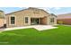 A well-maintained backyard featuring green grass, a gravel area, and a covered patio with sliding glass doors at 31096 N 133Rd Ave, Peoria, AZ 85383