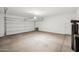 A clean, empty garage with white walls and a door. The garage has overhead lighting, and concrete flooring at 31096 N 133Rd Ave, Peoria, AZ 85383
