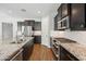 Modern kitchen featuring stainless steel appliances, granite countertops, and dark wood cabinetry at 31096 N 133Rd Ave, Peoria, AZ 85383
