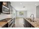 Modern kitchen featuring stainless steel appliances, granite countertops, and dark wood cabinetry at 31096 N 133Rd Ave, Peoria, AZ 85383