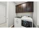 Well-organized laundry room with modern washer and dryer, and dark cabinets above, creating a functional space at 31096 N 133Rd Ave, Peoria, AZ 85383