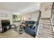 Bright living room with large window, blue couch, and staircase creates an inviting and spacious atmosphere at 3324 S Juniper St, Tempe, AZ 85282