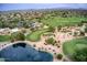 Picturesque aerial view of a lush golf course and pond near a residential community with mountain views at 4817 E Cielo Grande Ave, Phoenix, AZ 85054