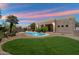 Lush backyard features a refreshing pool, green lawn, desert landscaping and a charming covered patio at 4817 E Cielo Grande Ave, Phoenix, AZ 85054