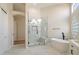 Modern bathroom featuring a glass shower, soaking tub, and marble tile flooring at 4817 E Cielo Grande Ave, Phoenix, AZ 85054