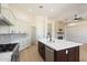 Modern kitchen with white cabinets, stainless steel appliances, and a dark wood island at 4817 E Cielo Grande Ave, Phoenix, AZ 85054