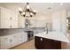 Modern kitchen with white cabinets, stainless steel appliances, and a dark wood island at 4817 E Cielo Grande Ave, Phoenix, AZ 85054