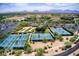 Aerial view of multiple tennis courts, parking, and resort complex against a backdrop of desert landscape and distant mountains at 4817 E Cielo Grande Ave, Phoenix, AZ 85054