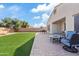 This backyard has a green artificial lawn with a brick patio, fire pit, and seating area to enjoy the outdoors at 5320 W Fawn Dr, Laveen, AZ 85339