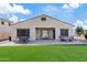 Backyard features artificial grass, a covered patio with seating, and mature desert landscaping at 5320 W Fawn Dr, Laveen, AZ 85339
