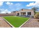 Manicured backyard with artificial turf, gravel landscaping and covered outdoor seating area at 5320 W Fawn Dr, Laveen, AZ 85339