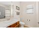 Bright bathroom featuring a wooden vanity with white countertop, decorative mirror and toilet at 5320 W Fawn Dr, Laveen, AZ 85339