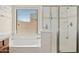 Bright bathroom with soaking tub, glass-enclosed shower, and tiled accents at 5320 W Fawn Dr, Laveen, AZ 85339