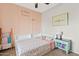 Charming bedroom with a pink accent wall, floral bedding, and colorful decorations at 5320 W Fawn Dr, Laveen, AZ 85339
