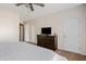 Comfortable bedroom with a dark dresser, wall-mounted TV, and neutral decor at 5320 W Fawn Dr, Laveen, AZ 85339
