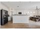 Open-concept kitchen featuring white cabinetry, stainless steel appliances, and a center island with bar seating at 5320 W Fawn Dr, Laveen, AZ 85339