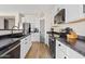 Modern kitchen boasting white cabinets, stainless steel appliances, dark countertops, and hardwood flooring at 5320 W Fawn Dr, Laveen, AZ 85339