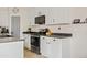 Contemporary kitchen showcasing white cabinets, stainless steel appliances, dark countertops and fixtures, and modern hardwood floors at 5320 W Fawn Dr, Laveen, AZ 85339