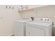 Functional laundry room with white washer and dryer, shelving, and ample space at 5320 W Fawn Dr, Laveen, AZ 85339
