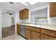 Well-lit kitchen with stainless steel dishwasher, natural wood cabinets, view through window into another room at 5358 S Farmer Ave, Tempe, AZ 85283