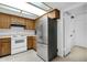 Kitchen features wood cabinetry, white oven, range hood, and stainless steel refrigerator at 5358 S Farmer Ave, Tempe, AZ 85283