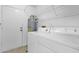 Functional laundry area with washer, dryer, water heater, wire rack shelving, and access door at 5358 S Farmer Ave, Tempe, AZ 85283