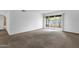 Carpeted living area featuring sliding glass doors, providing ample natural light and yard access at 5358 S Farmer Ave, Tempe, AZ 85283