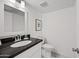 Bright bathroom featuring white cabinets, dark countertops, and a modern sink and toilet at 5632 S Hurricane Ct # C, Tempe, AZ 85283