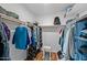 A walk-in closet with organizers, rods, shelves, with a white chair and modern rug at 5632 S Hurricane Ct # C, Tempe, AZ 85283