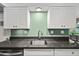 Contemporary kitchen featuring white cabinets, stainless steel sink, and modern fixtures at 5632 S Hurricane Ct # C, Tempe, AZ 85283