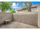 Private outdoor patio featuring a light-colored textured wall, concrete flooring, and a small plastic table at 5632 S Hurricane Ct # C, Tempe, AZ 85283