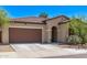 Exterior view of home showcasing a two-car garage, stucco exterior, and tiled roof at 6413 S 47Th Dr, Laveen, AZ 85339