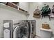 Well-equipped laundry room with modern washer and dryer units, storage shelves, and decor at 6413 S 47Th Dr, Laveen, AZ 85339