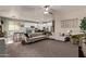 Open concept living room showcasing a plush sectional sofa, ceiling fan, and decor at 6413 S 47Th Dr, Laveen, AZ 85339