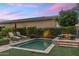 Cozy backyard with a pool, lounge chairs, a fire pit and lush greenery, perfect for outdoor relaxation and entertainment at 6929 E Montreal Pl, Scottsdale, AZ 85254